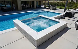 Luxury custom pool with integrated spa and modern concrete deck design