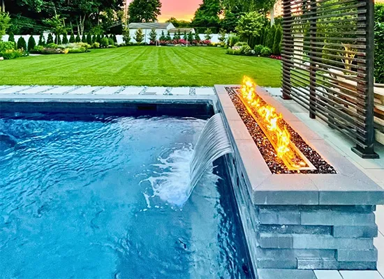 Luxury backyard pool with modern fire feature and manicured lawn in high-end residential outdoor living space