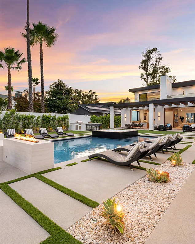 Luxury backyard pool design featuring custom swimming pool, spa, lounge seating, and modern outdoor living space at sunset