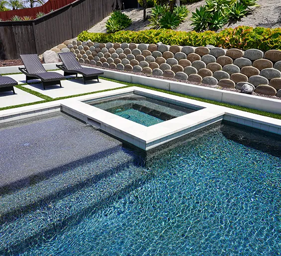 Luxury backyard pool with spa and lounge area featuring high-end custom pool design and landscaping