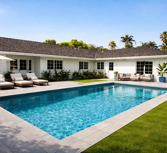 Luxury backyard pool with custom construction featuring loungers and modern white residence